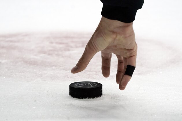 An official picks up a puck in the third period of an NHL hockey game between the Nashville Predators and the Chicago Blackhawks Monday, April 19, 2021, in Nashville, Tenn. (AP Photo/Mark Humphrey)