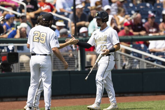 Vanderbilt's Dominic Keegan (12), right, returns to the dugout after scoring off a single by CJ Rodriguez in the fourth inning against North Carolina State during a baseball game in the College World Series Friday, June 25, 2021, at TD Ameritrade Park in Omaha, Neb. (AP Photo/Rebecca S. Gratz)