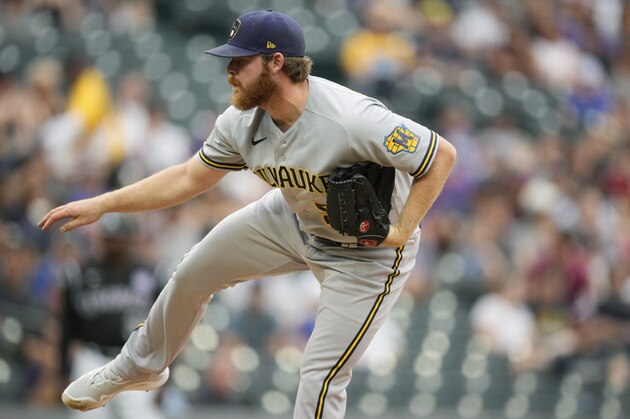 Milwaukee Brewers starting pitcher Brandon Woodruff watches a throw to a Colorado Rockies batter during the first inning of a baseball game Thursday, June 17, 2021, in Denver. (AP Photo/David Zalubowski)