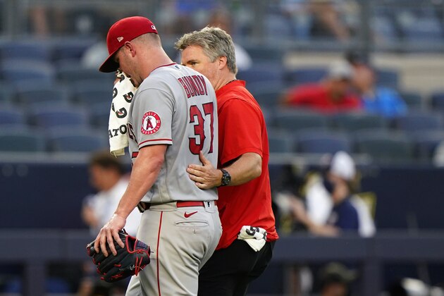 Los Angeles Angels starting pitcher Dylan Bundy (37) is escorted off the field by a trainer after falling ill during the second inning of a baseball game against the New York Yankees, Monday, June 28, 2021, at Yankee Stadium in New York. (AP Photo/Kathy Willens)