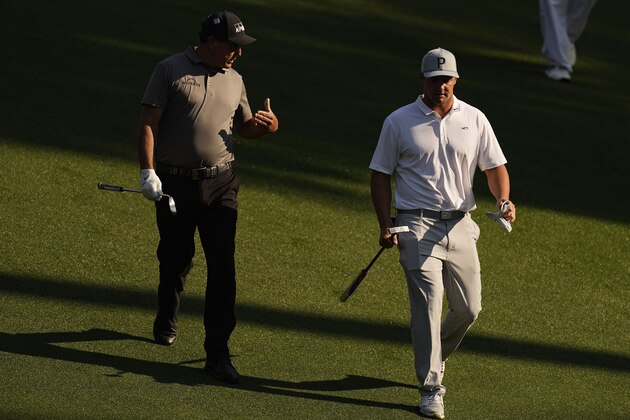 Phil Mickelson speaks with Bryson DeChambeau as they walk down the 10th fairway during a practice round for the Masters golf tournament on Wednesday, April 7, 2021, in Augusta, Ga. (AP Photo/Matt Slocum)