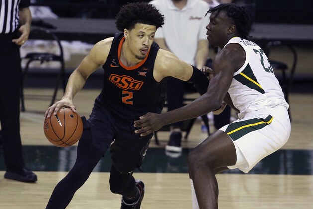 Oklahoma State guard Cade Cunningham (2) drives the ball against Baylor forward Jonathan Tchamwa Tchatchoua (23) in the second half of an NCAA college basketball game, Thursday, March 4, 2021, in Waco, Texas. (AP Photo/Jerry Larson)