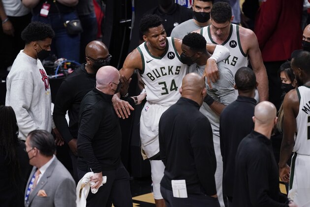 Milwaukee Bucks' Giannis Antetokounmpo (34) is helped off the court after he and Atlanta Hawks' Clint Capela fell during the second half of Game 4 of the NBA basketball Eastern Conference finals Tuesday, June 29, 2021, in Atlanta. (AP Photo/Brynn Anderson)