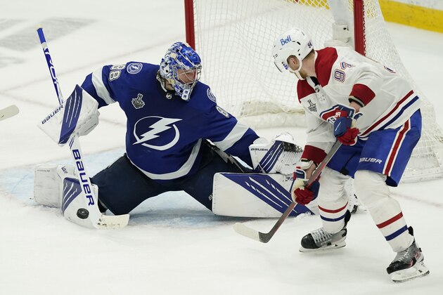 Tampa Bay Lightning goaltender Andrei Vasilevskiy (88) deflects a shot by Montreal Canadiens right wing Corey Perry (94) during the third period in Game 2 of the NHL hockey Stanley Cup finals, Wednesday, June 30, 2021, in Tampa, Fla. (AP Photo/Gerry Broome)