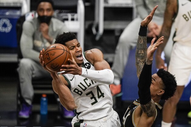 Milwaukee Bucks forward Giannis Antetokounmpo (34) defends the ball against Atlanta Hawks forward John Collins (20) during the second half of Game 4 of the NBA Eastern Conference basketball finals Tuesday, June 29, 2021, in Atlanta. (AP Photo/Brynn Anderson)
