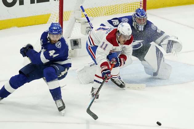 Montreal Canadiens right wing Brendan Gallagher (11) plays the puck next to Tampa Bay Lightning defenseman Jan Rutta (44) and goaltender Andrei Vasilevskiy (88) during the second period in Game 2 of the NHL hockey Stanley Cup finals, Wednesday, June 30, 2021, in Tampa, Fla. (AP Photo/Gerry Broome)