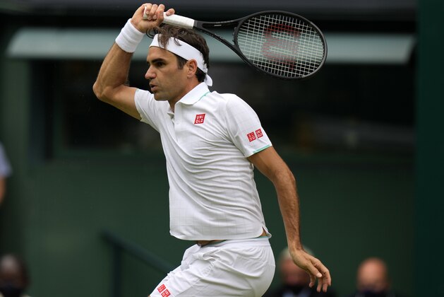 Switzerland's Roger Federer plays a return during the men's singles third round match against Britain's Cameron Norrie on day six of the Wimbledon Tennis Championships in London, Saturday July 3, 2021. (AP Photo/Alastair Grant)