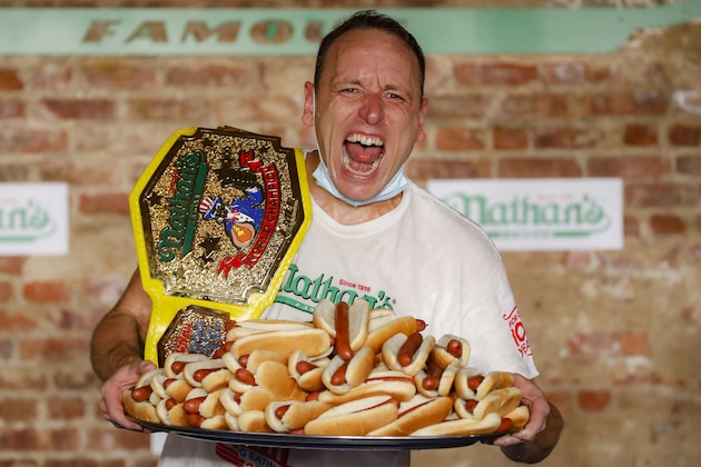 Competitive eater Joey Chestnut celebrates after setting a new world record with 75 hot dogs to win the men's division of the Nathan's Famous July Fourth hot dog eating contest, Saturday, July 4, 2020, in the Brooklyn borough of New York. (AP Photo/John Minchillo)