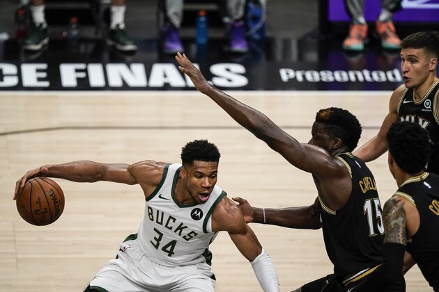 Milwaukee Bucks forward Giannis Antetokounmpo (34) defends the ball against Atlanta Hawks center Clint Capela (15) during the second half of Game 4 of the NBA Eastern Conference basketball finals Tuesday, June 29, 2021, in Atlanta. (AP Photo/Brynn Anderson)