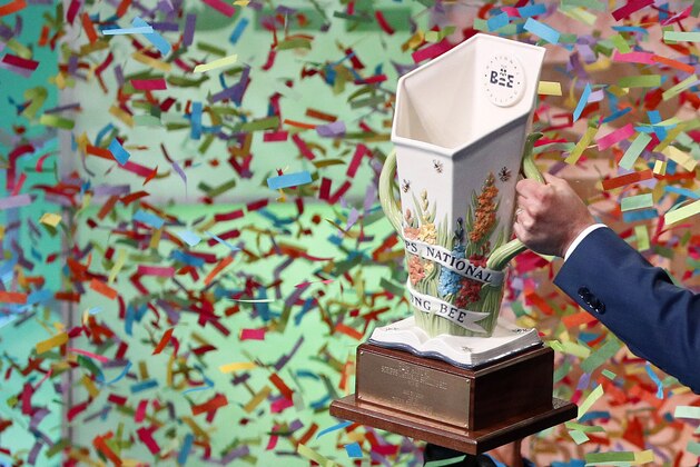 E.W. Scripps CEO Adam Symson carries a trophy for eight co-champions of the Scripps National Spelling Bee as confetti falls, early Friday, May 31, 2019, in Oxon Hill, Md. The spelling bee ended in unprecedented 8-way championship tie after organizers ran out of challenging words. (AP Photo/Patrick Semansky)