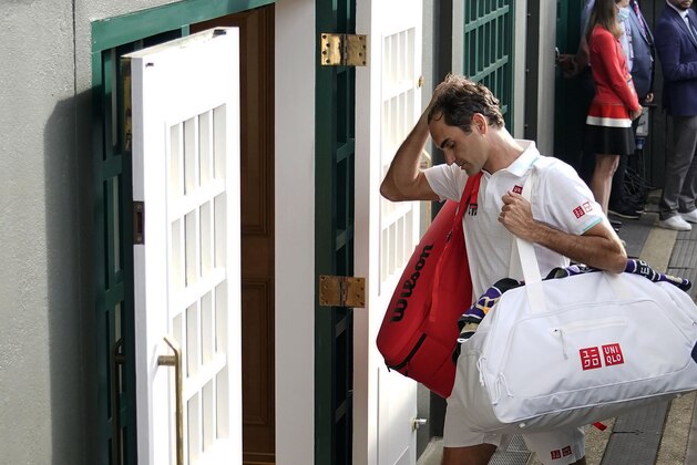 Switzerland's Roger Federer leaves the court after being defeated by Poland's Hubert Hurkacz during the men's singles quarterfinals match on day nine of the Wimbledon Tennis Championships in London, Wednesday, July 7, 2021. (AP Photo/Alberto Pezzali)