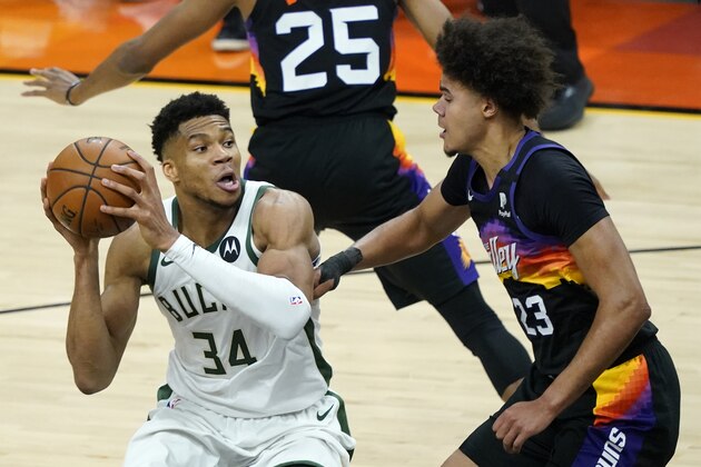 Milwaukee Bucks forward Giannis Antetokounmpo (34) looks to pass as Phoenix Suns forward Cameron Johnson (23)defends during the second half of Game 1 of basketball's NBA Finals, Tuesday, July 6, 2021, in Phoenix. (AP Photo/Matt York)