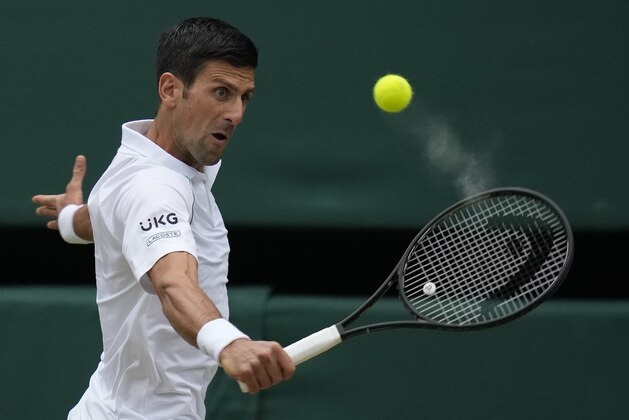 Serbia's Novak Djokovic plays a return to Canada's Denis Shapovalov during the men's singles semifinals match on day eleven of the Wimbledon Tennis Championships in London, Friday, July 9, 2021. (AP Photo/Kirsty Wigglesworth)