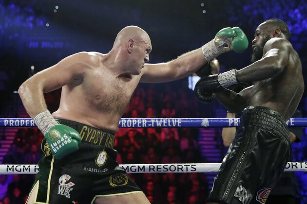 FILE - In this Feb. 22, 2020, file photo, Tyson Fury, left, of England, fights Deontay Wilder during a WBC heavyweight championship boxing match in Las Vegas. Fury is turning his attention to an all-British heavyweight unification bout with Anthony Joshua early next year after ending plans for a third fight with Deontay Wilder. Fury claimed the WBC belt from Wilder with a seventh-round stoppage in their rematch in Las Vegas in February and the British boxerâ€™s U.S. promoter, Bob Arum, was looking to stage a third fight between them in front of 15,000 spectators at the home of NFL team Las Vegas Raiders on Dec. 19. (AP Photo/Isaac Brekken, File)