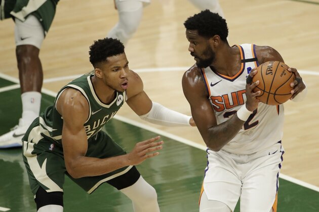 Phoenix Suns' Deandre Ayton controls the ball while Milwaukee Bucks' Giannis Antetokounmpo defends during the first half of Game 3 of basketball's NBA Finals Sunday, July 11, 2021, in Milwaukee. (AP Photo/Aaron Gash)