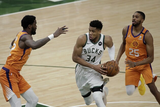 Milwaukee Bucks forward Giannis Antetokounmpo (34) drives to the basket between Phoenix Suns center Deandre Ayton, left, and forward Mikal Bridges (25) during the second half of Game 4 of basketball's NBA Finals Wednesday, July 14, 2021, in Milwaukee. (AP Photo/Aaron Gash)