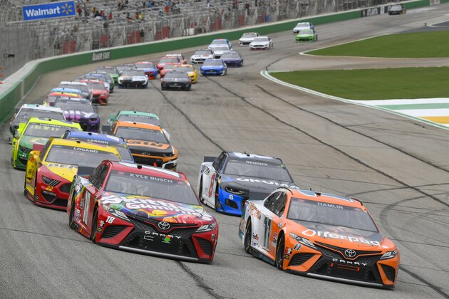 Kyle Busch, left, and Denny Hamlin (11) run in front after a release from the first caution during a NASCAR Cup Series auto race, Sunday, July, 11, 2021, in Hampton, Ga. (AP Photo/John Amis)
