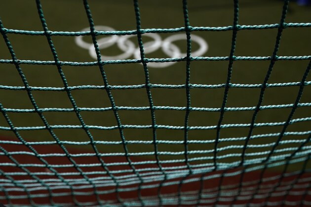 The Olympic rings painted on the field are seen through a net as U.S. softball players take batting practice at the Fukushima Azuma Baseball Stadium ahead of the 2020 Summer Olympics, Tuesday, July 20, 2021, in Fukushima, Japan. (AP Photo/Jae C. Hong)