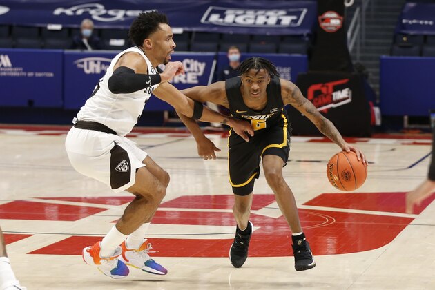 VCU's Nah'Shon Hyland, right, brings the ball up court against St. Bonaventure's Jalen Adaway during the second half of an NCAA college basketball championship game for the Atlantic Ten Conference tournament Sunday, March 14, 2021, in Dayton, Ohio.  (AP Photo/Jay LaPrete)