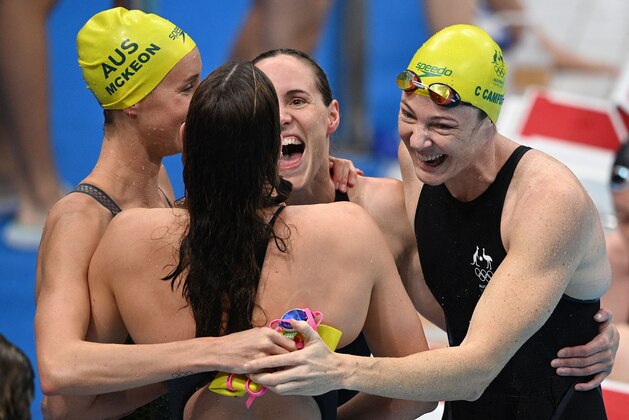 Australia's Cate Campbell (R) and teammates celebrate after setting a world record and winning the final of the women's 4x100m freestyle relay swimming event during the Tokyo 2020 Olympic Games at the Tokyo Aquatics Centre in Tokyo on July 25, 2021. (Photo by Oli SCARFF / AFP) (Photo by OLI SCARFF/AFP via Getty Images)