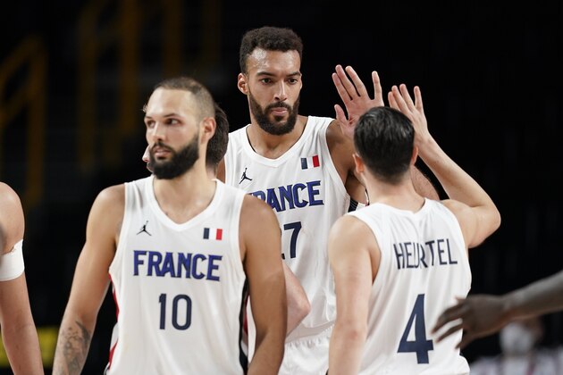 France's Rudy Gobert, center, celebrates with teammates after a men's basketball preliminary round game against the United States at the 2020 Summer Olympics, Sunday, July 25, 2021, in Saitama, Japan. France won 83-76. (AP Photo/Charlie Neibergall)
