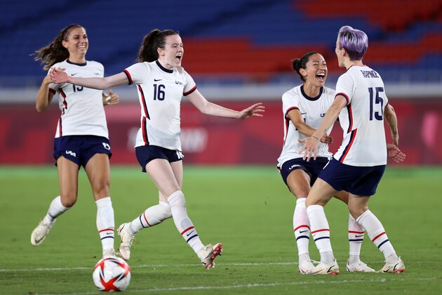YOKOHAMA, JAPAN - JULY 30: Alex Morgan #13, Rose Lavelle #16, Christen Press #11 and Megan Rapinoe #15 of Team United States celebrate following their team's victory in the penalty shoot out after the Women's Quarter Final match between Netherlands and United States on day seven of the Tokyo 2020 Olympic Games at International Stadium Yokohama on July 30, 2021 in Yokohama, Kanagawa, Japan. (Photo by Laurence Griffiths/Getty Images)