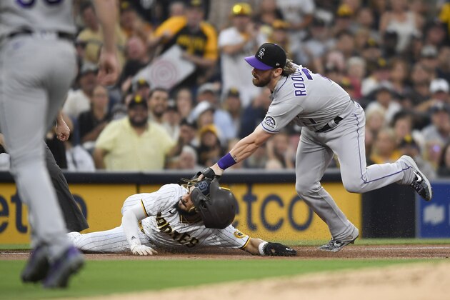 SAN DIEGO, CA - JULY 30: Fernando Tatis Jr. #23 of the San Diego Padres is tagged out at third base by Brendan Rodgers #7 of the Colorado Rockies during the first inning of a baseball game at Petco Park on July 30, 2021 in San Diego, California. Tatis was injured on play.  (Photo by Denis Poroy/Getty Images)