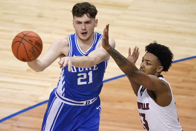 Duke forward Matthew Hurt (21) passes the ball in front of Louisville guard David Johnson (13) during the first half of an NCAA college basketball game in the second round of the Atlantic Coast Conference tournament in Greensboro, N.C., Wednesday, March 10, 2021. (AP Photo/Gerry Broome)