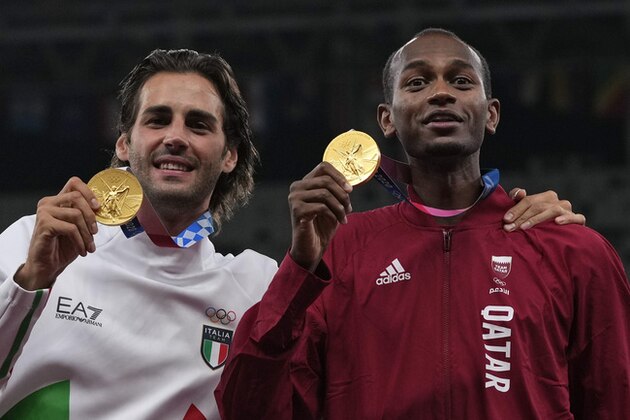 Joint gold medalists Mutaz Barshim, of Qatar, and Gianmarco Tamberi, left, of Italy pose for a photo following the men's high jump final at the 2020 Summer Olympics, Monday, Aug. 2, 2021, in Tokyo. (AP Photo/Francisco Seco)