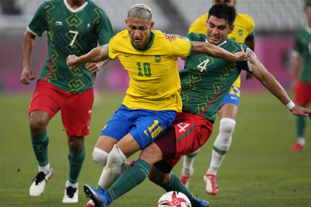 Brazil's Richarlison (10) and Mexico's Jesus Angulo (4) battle for the ball during a men's soccer semifinal match at the 2020 Summer Olympics, Tuesday, Aug. 3, 2021, in Kashima, Japan. (AP Photo/Andre Penner)