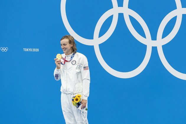 Katie Ledecky shows her gold medal from the women's 1,500-meter freestyle in Tokyo, the first time the event has been part of the Olympics.