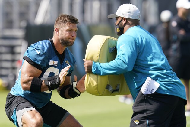 Jacksonville Jaguars tight end Tim Tebow, left, performs a drill during an NFL football practice, Tuesday, June 15, 2021, in Jacksonville, Fla. (AP Photo/John Raoux)