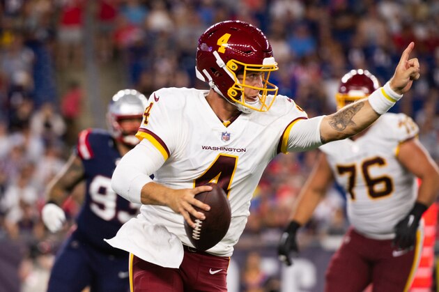 FOXBOROUGH, MA - AUGUST 12: Taylor Heinicke #4 of of the Washington Football Team points while running with the ball in the first half against the New England Patriots at Gillette Stadium on  August 12, 2021 in Foxborough, Massachusetts. (Photo by Kathryn Riley/Getty Images)