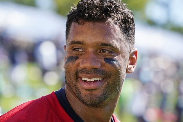 Seattle Seahawks quarterback Russell Wilson smiles as he walks off the field after an NFL football practice in Renton, Wash., Wednesday, Aug. 11, 2021. (AP Photo/Elaine Thompson)