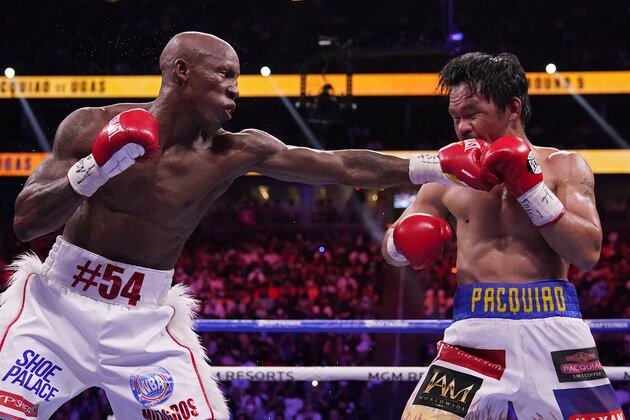 Yordenis Ugas, of Cuba, hits Manny Pacquiao, of the Philippines, in a welterweight championship boxing match Saturday, Aug. 21, 2021, in Las Vegas. (AP Photo/John Locher) Yordenis Ugas, of Cuba, hits Manny Pacquiao, of the Philippines, in a welterweight championship boxing match Saturday, Aug. 21, 2021, in Las Vegas. (AP Photo/John Locher)
