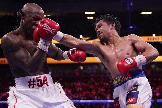 Manny Pacquiao, right, of the Philippines, hits Yordenis Ugas, of Cuba, in a welterweight championship boxing match Saturday, Aug. 21, 2021, in Las Vegas. (AP Photo/John Locher)