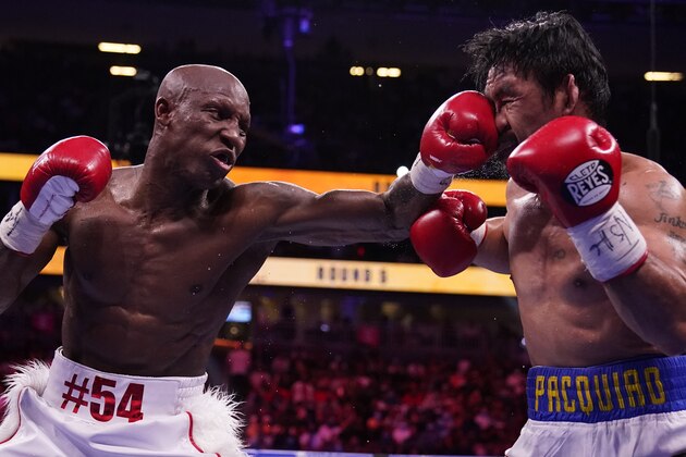 Yordenis Ugas, left, of Cuba, hits Manny Pacquiao, of the Philippines, in a welterweight championship boxing match Saturday, Aug. 21, 2021, in Las Vegas. (AP Photo/John Locher)