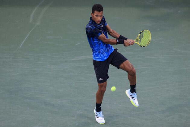 Felix Auger-Aliassime, of Canada, returns to Stefanos Tsitsipas, of Greece, during the Western & Southern Open tennis tournament Friday, Aug. 20, 2021, in Mason, Ohio. (AP Photo/Aaron Doster)