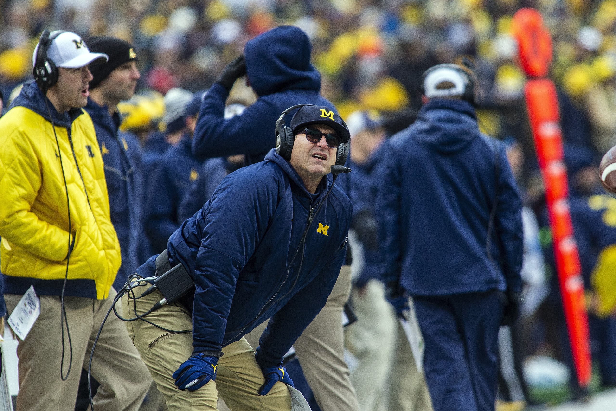 Michigan head coach Jim Harbaugh leans on his knees while looking up at the scoreboard in the third quarter of an NCAA college football game against Ohio State in Ann Arbor, Mich., Saturday, Nov. 30, 2019. Ohio State won 56-27. (AP Photo/Tony Ding)