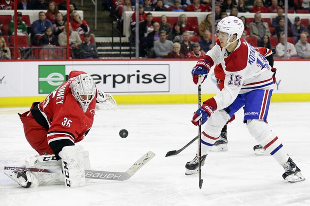 Carolina Hurricanes goalie Curtis McElhinney (35) blocks Montreal Canadiens' Jesperi Kotkaniemi (15), of Finland, during the second period of an NHL hockey game in Raleigh, N.C., Sunday, March 24, 2019. (AP Photo/Gerry Broome)