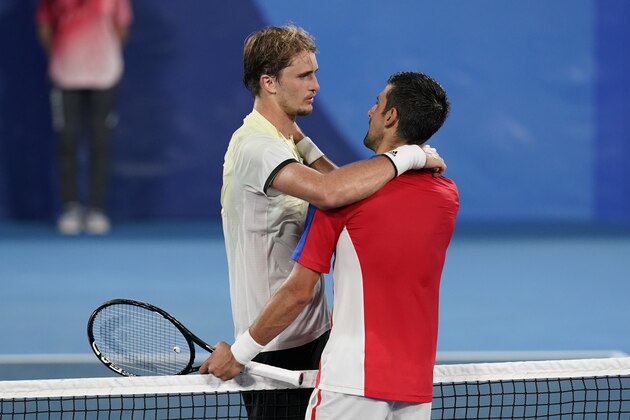 Alexander Zverev, left, of Germany, speaks with Novak Djokovic, of Serbia, after defeating Djokovic in the semifinal round of the men's tennis competition at the 2020 Summer Olympics, Friday, July 30, 2021, in Tokyo, Japan. (AP Photo/Patrick Semansky)