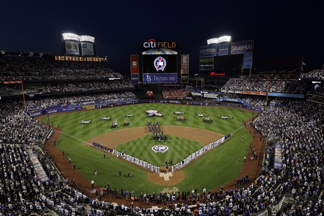 The New York Yankees and the New York Mets line up together along the baselines for the 20th anniversary of the 9/11 terrorist attacks before a baseball game on Saturday, Sept. 11, 2021, in New York. (AP Photo/Adam Hunger)