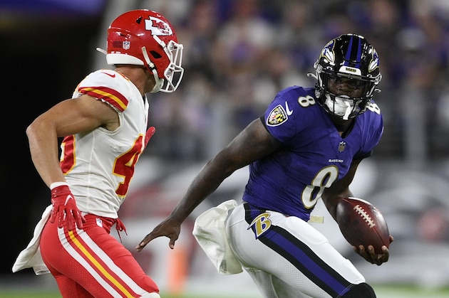Baltimore Ravens quarterback Lamar Jackson, right, rushes past Kansas City Chiefs defensive back Daniel Sorensen in the first half of an NFL football game, Sunday, Sept. 19, 2021, in Baltimore. (AP Photo/Nick Wass)