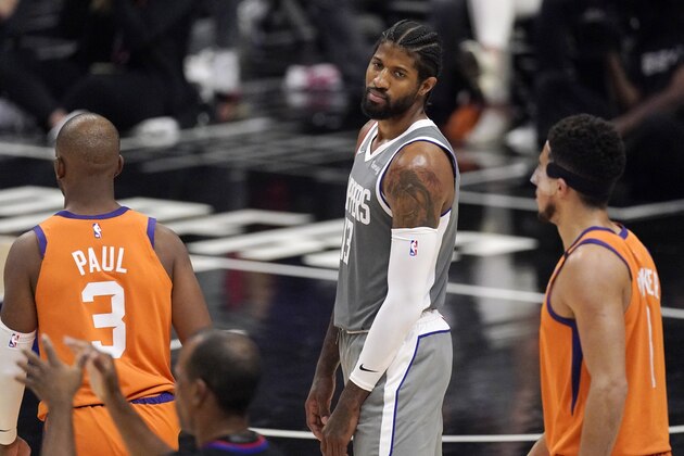 Los Angeles Clippers guard Paul George, center, looks toward referees after being charged with a foul as Phoenix Suns guard Chris Paul, left, and guard Devin Booker stand by during the second half in Game 4 of the NBA basketball Western Conference Finals Saturday, June 26, 2021, in Los Angeles. (AP Photo/Mark J. Terrill)