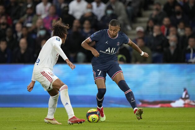 PSG's Kylian Mbappe, right, runs with the ball during the French League One soccer match between Paris Saint-Germain and Lyon at the Parc des Princes in Paris Sunday, Sept. 19, 2021. (AP Photo/Francois Mori)