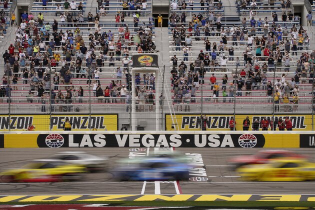 Fans watch as cars pass by during a NASCAR Cup Series auto race Sunday, March 7, 2021, in Las Vegas. (AP Photo/John Locher)