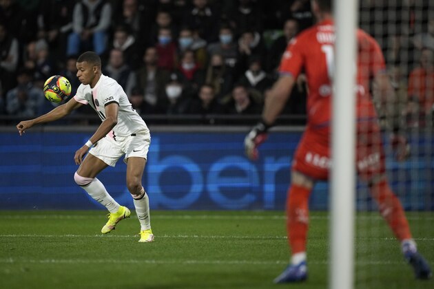 PSG's Kylian Mbappe, left, controls the ball in front of Metz's goalkeeper Alexandre Oukidja during the French League One soccer match between FC Metz and Paris Saint-Germain at Saint Symphorien stadium, in Metz, eastern France, Wednesday, Sept. 22, 2021. (AP Photo/Christophe Ena)