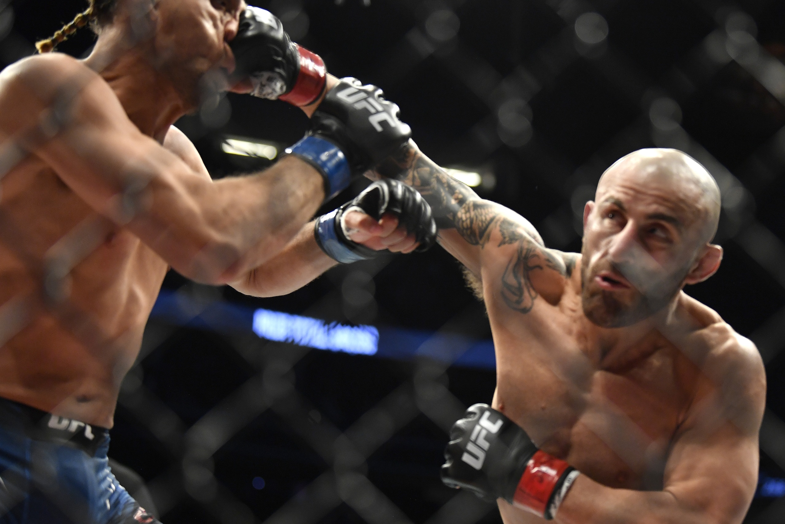 LAS VEGAS, NEVADA - SEPTEMBER 25: (R-L) Alexander Volkanovski of Australia punches Brian Ortega in their UFC featherweight championship fight during the UFC 266 event on September 25, 2021 in Las Vegas, Nevada. (Photo by Chris Unger/Zuffa LLC)