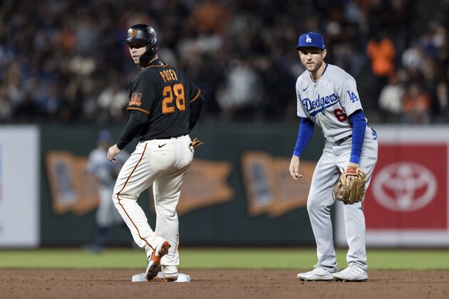 San Francisco Giants' Buster Posey (28) and Los Angeles Dodgers second baseman Trea Turner (6) watch the play at first base in the sixth inning of a baseball game in San Francisco, Saturday, Sept. 4, 2021. (AP Photo/John Hefti)