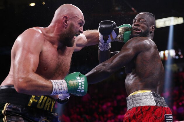 Tyson Fury, of England, lands a left to Deontay Wilder in a heavyweight championship boxing match Saturday, Oct. 9, 2021, in Las Vegas. (AP Photo/Chase Stevens)